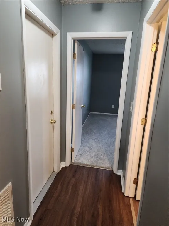 Hallway featuring wood finished floors and baseboards