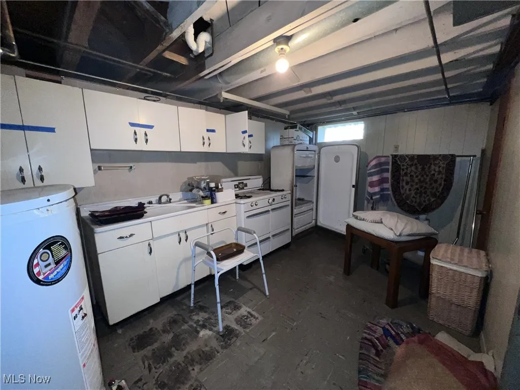 Basement featuring water heater and a sink