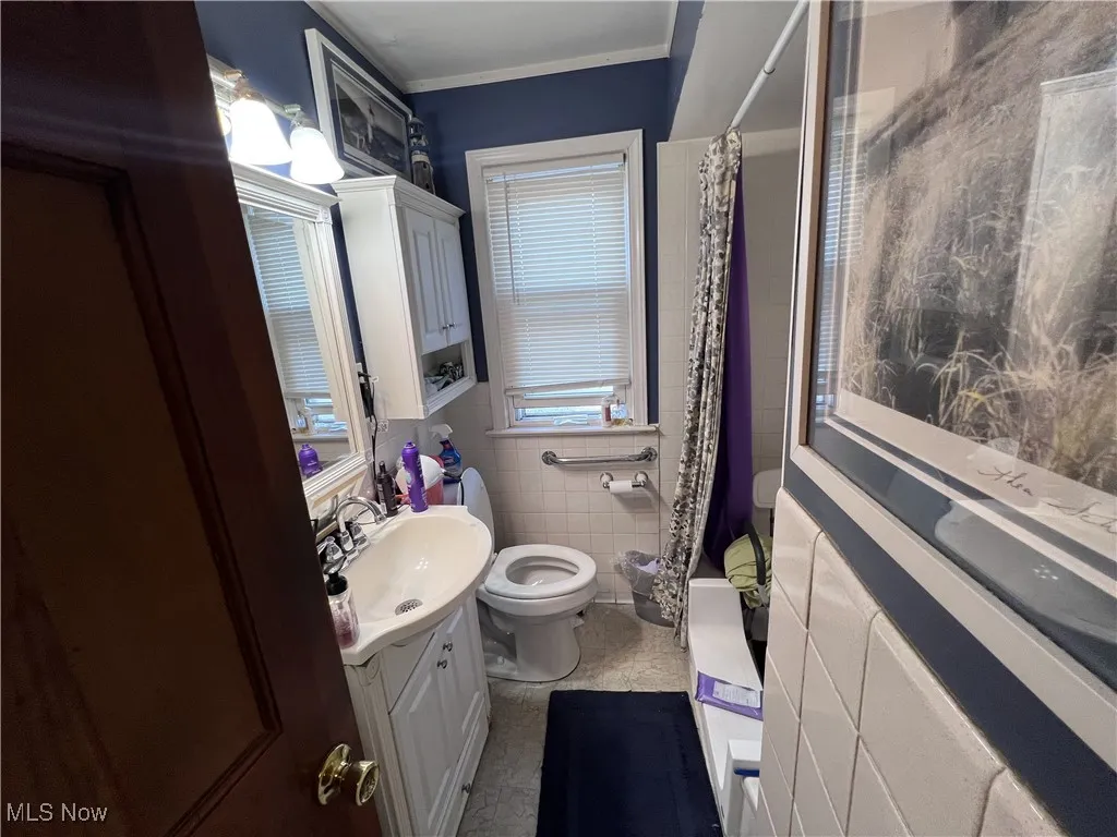 Full bath featuring vanity and tile walls