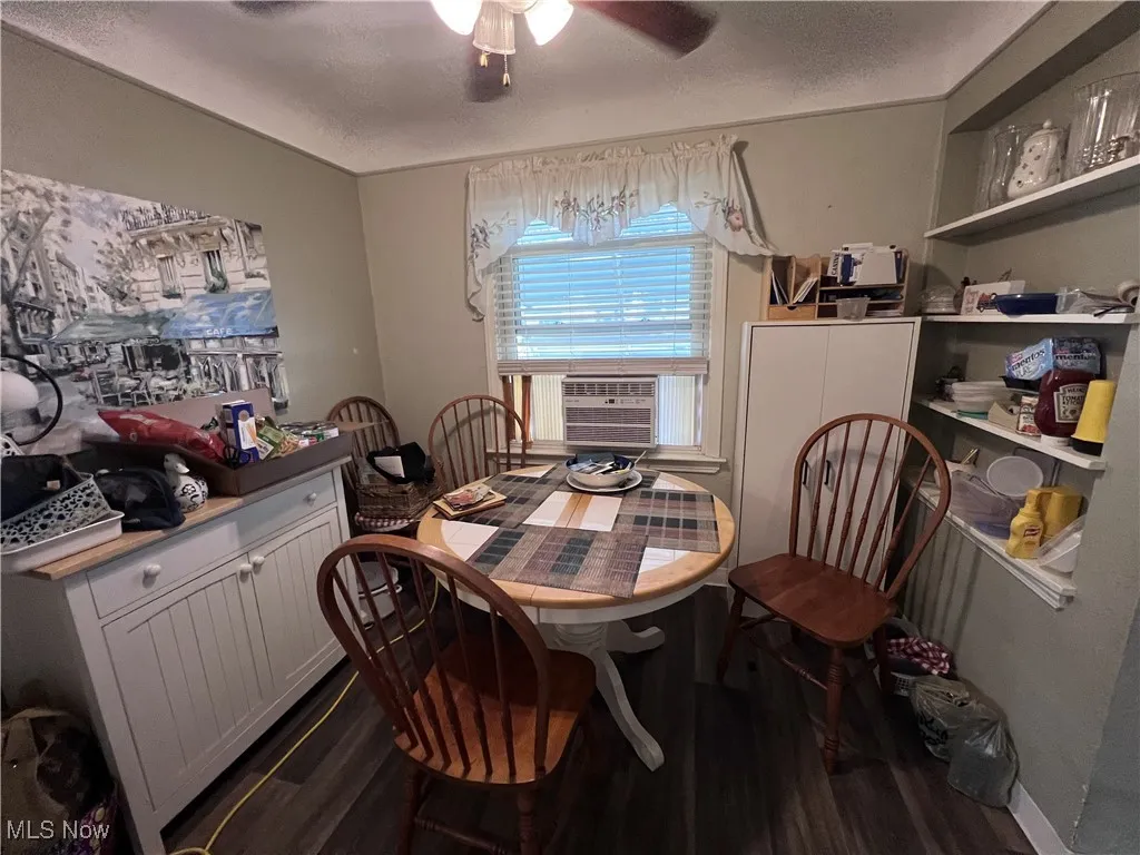 Dining area featuring dark wood-style floors, a ceiling fan, and cooling unit