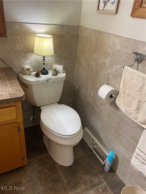 Bathroom featuring tile walls and vanity