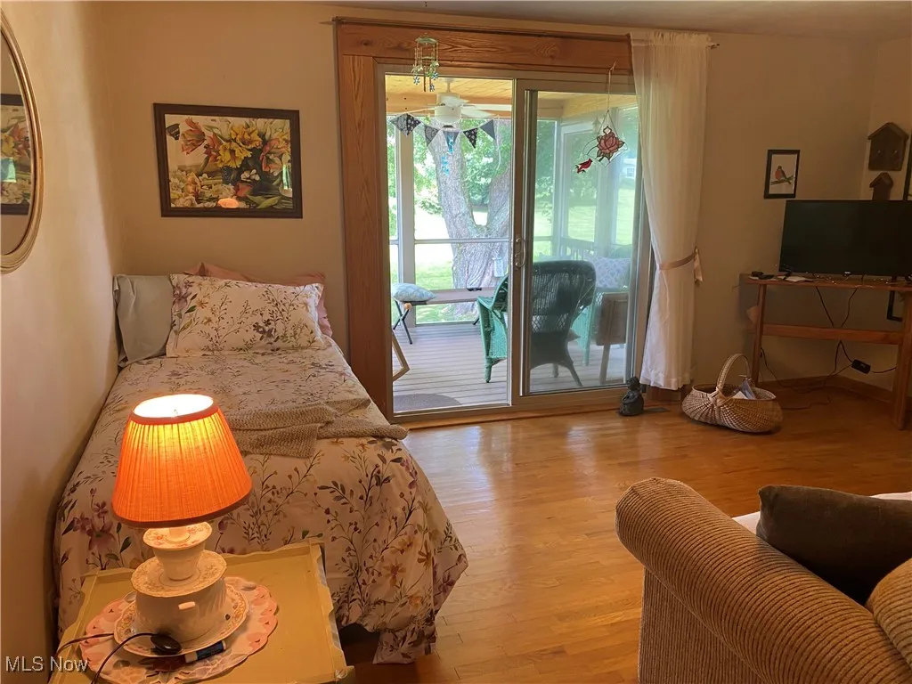 Bedroom with access to outside and wood finished floors