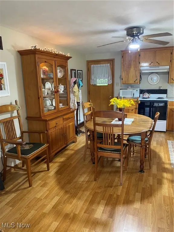 Dining area with light wood-style floors and a ceiling fan