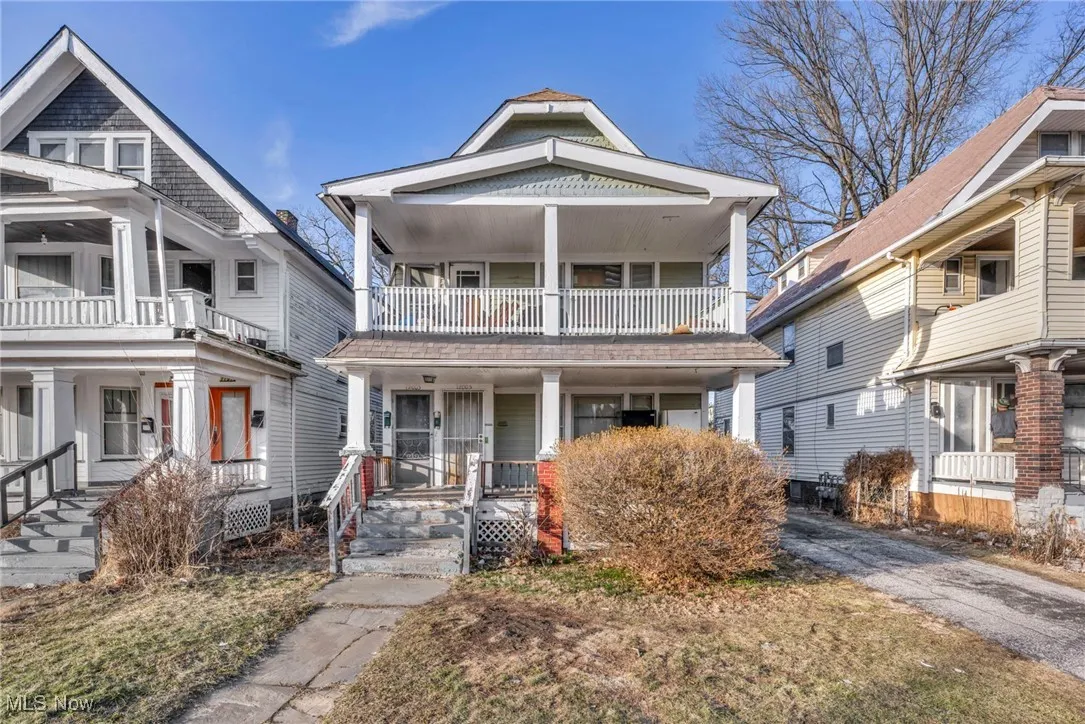 View of front facade with covered porch and a balcony