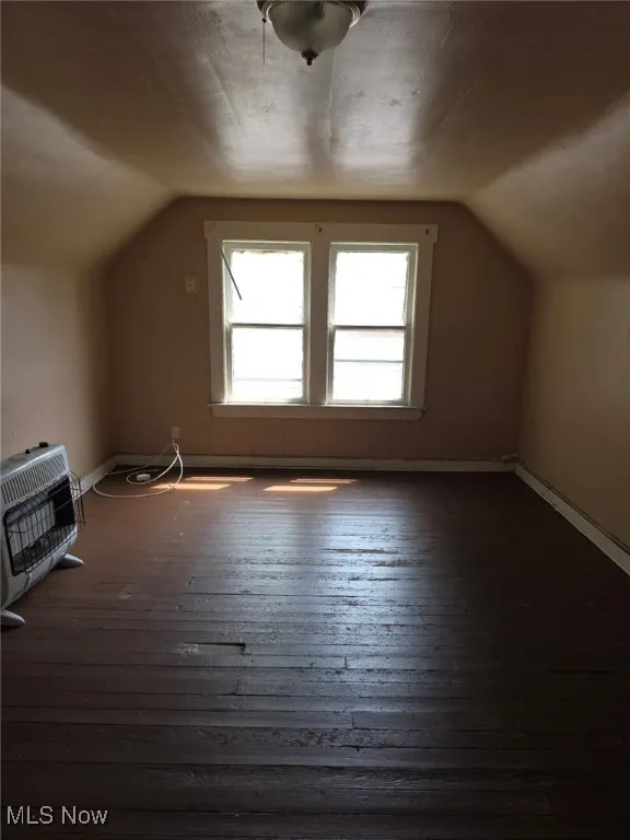 Additional living space with lofted ceiling, heating unit, and hardwood / wood-style floors (Bedroom)