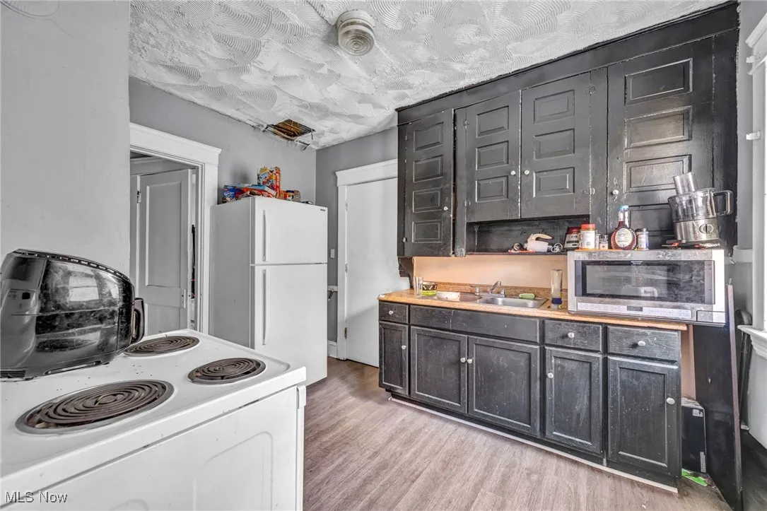 Kitchen with white appliances, light countertops, and light wood-type flooring