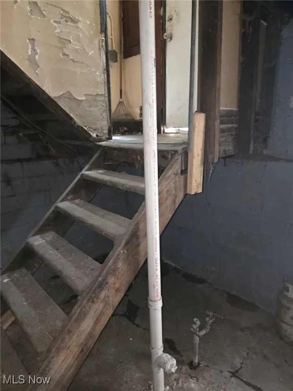 Staircase featuring concrete block wall (Updated Plumbing)