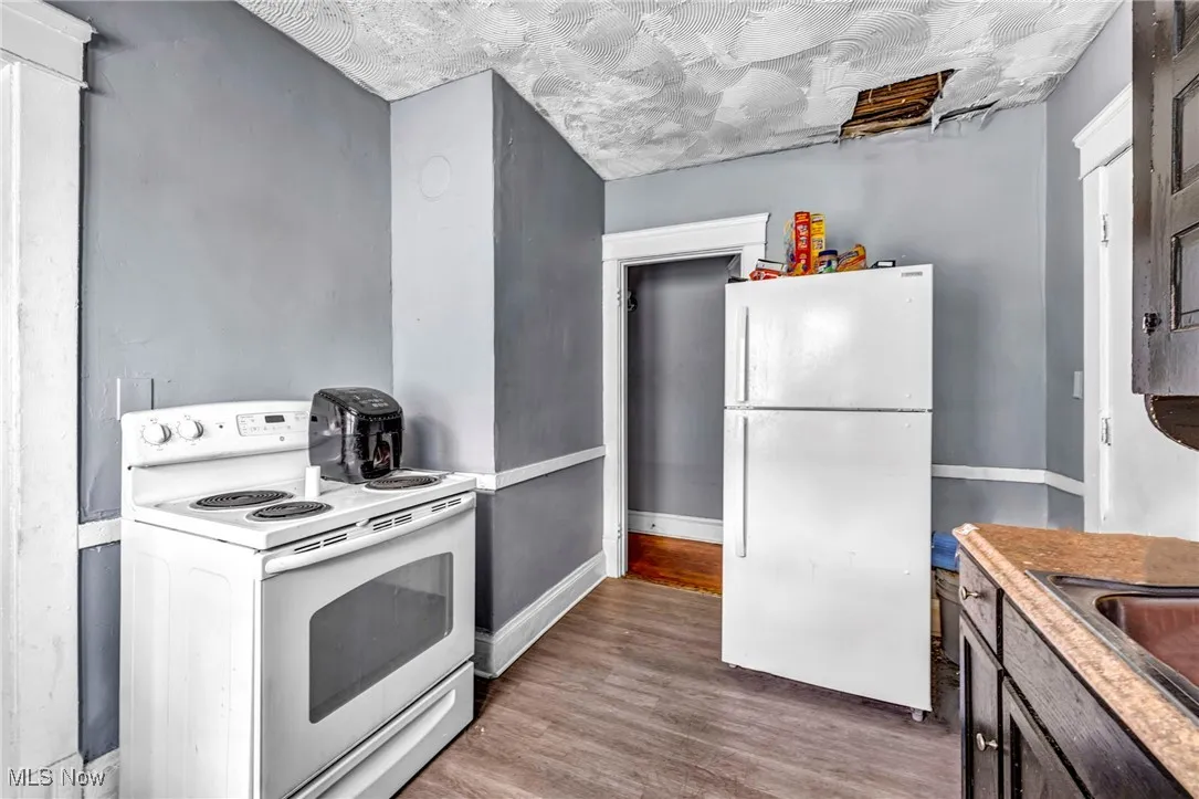 Kitchen with white appliances, wood finished floors, and light countertops