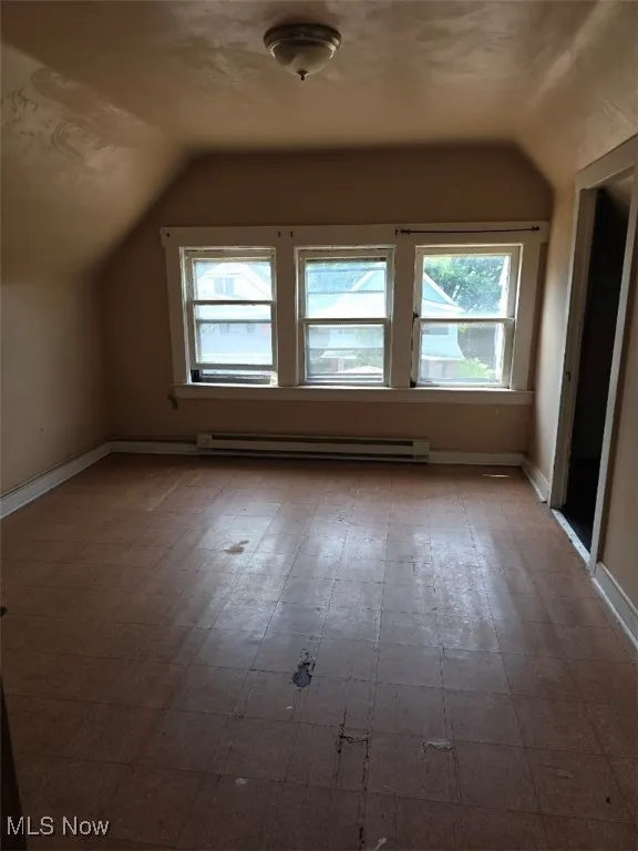 Bonus room with lofted ceiling and a baseboard heating unit
