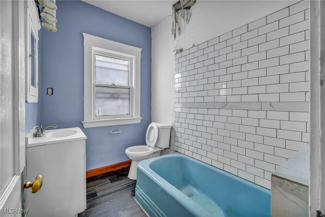 Full bath with vanity and wood finished floors