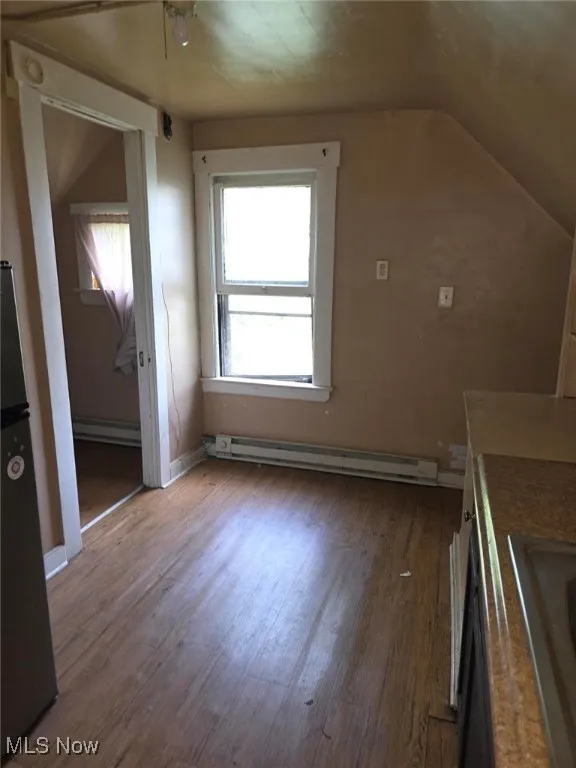  featuring a baseboard radiator, wood finished floors, lofted ceiling, and a baseboard heating unit (3rd Floor)