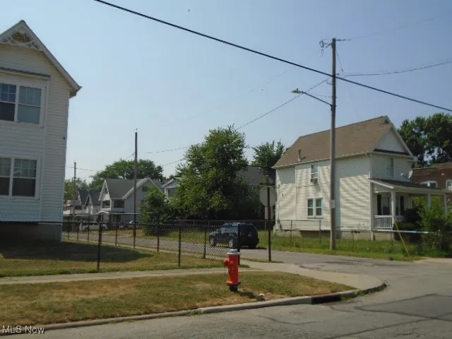 View of asphalt street featuring traffic signs, curbs, and a residential view