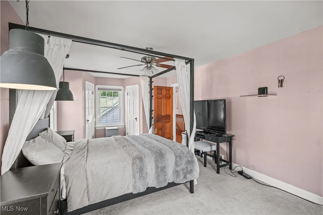 Carpeted bedroom featuring baseboards and ceiling fan