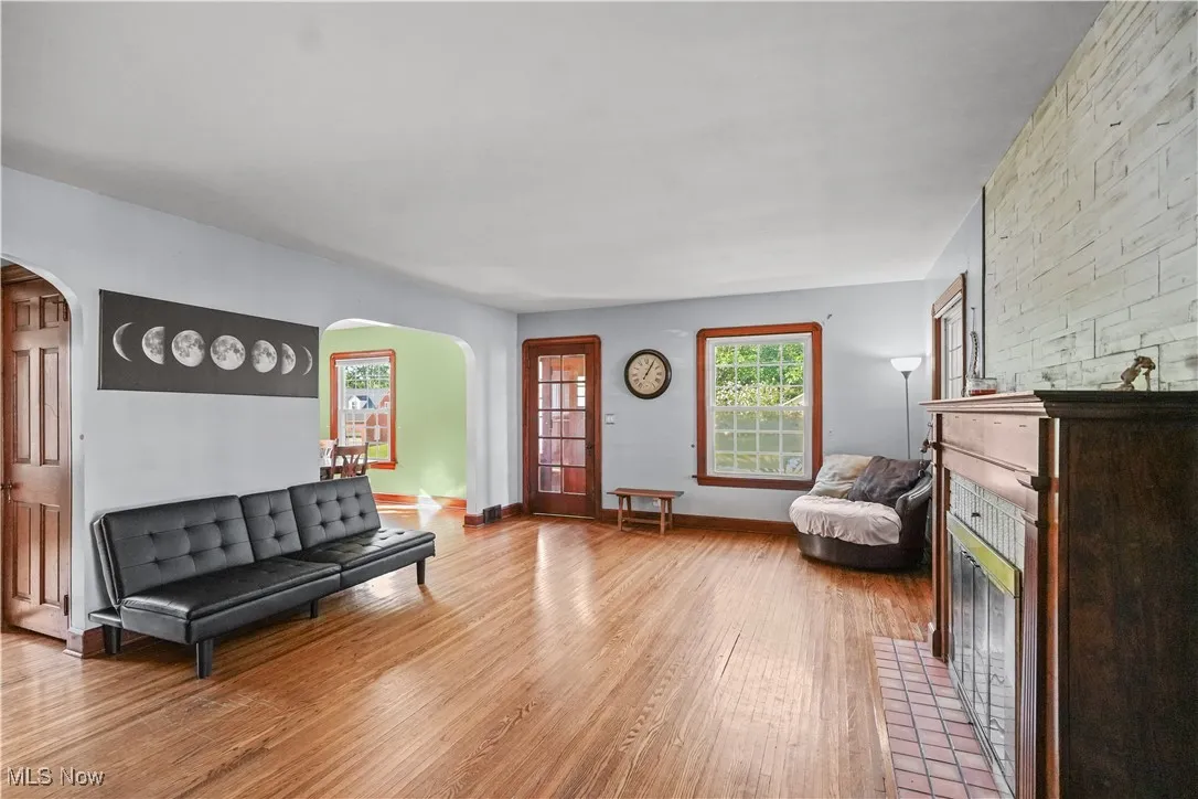 Living room with arched walkways and light wood-style flooring