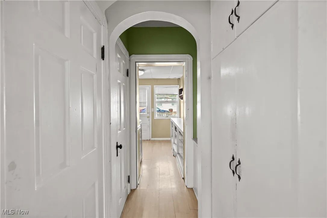 Hall with light wood-style floors and arched walkways