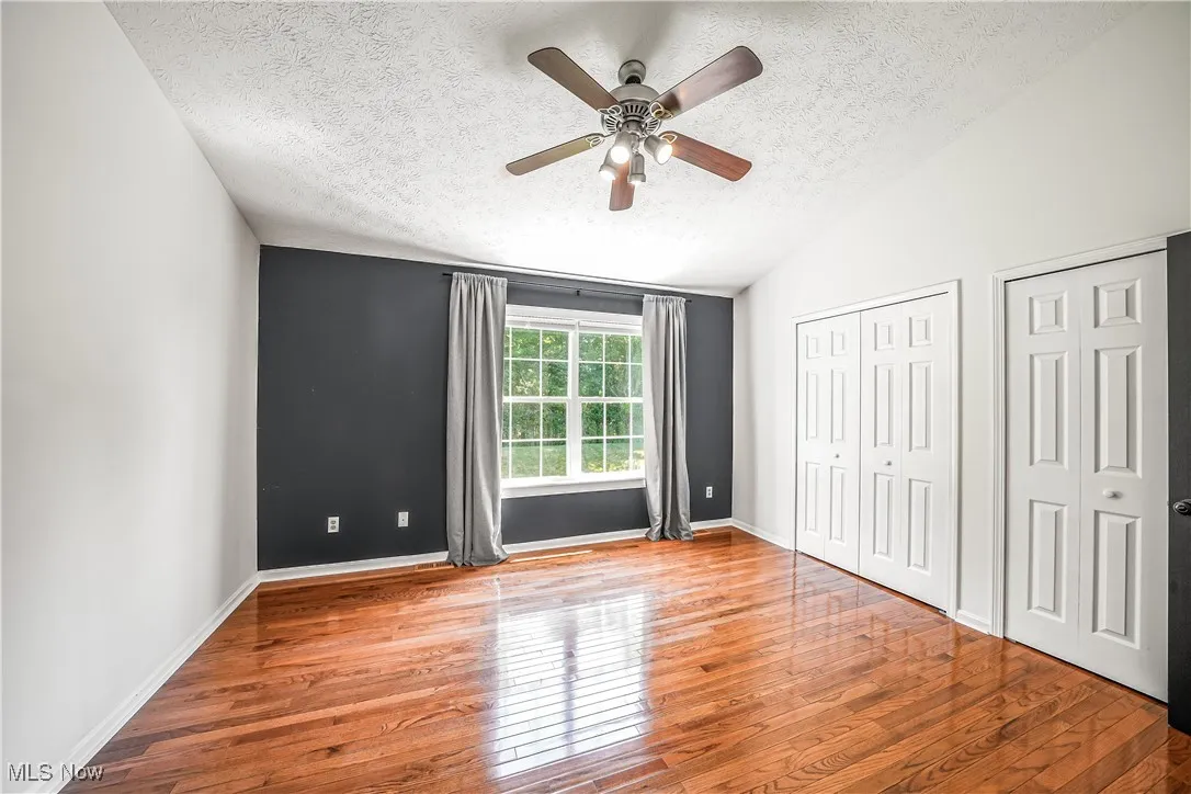 Primary Bedroom with Hardwood Flooring, Dual Closets
