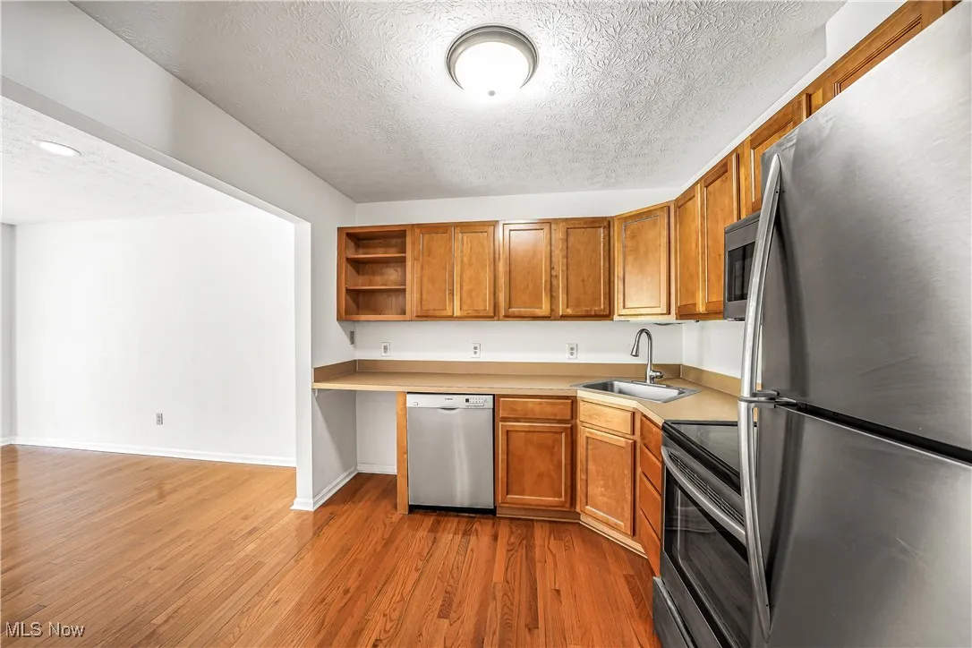 Open Concept Kitchen with Stainless Steel Appliances and Hardwood Flooring