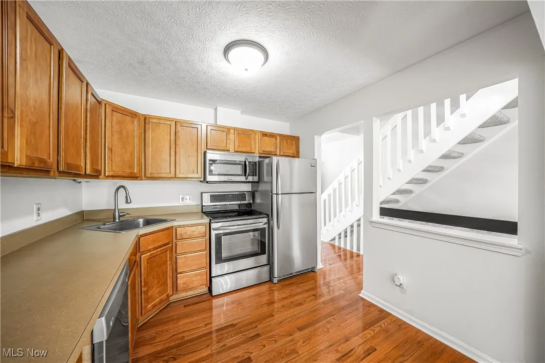 Open Concept Kitchen with Stainless Steel Appliances and Hardwood Flooring
