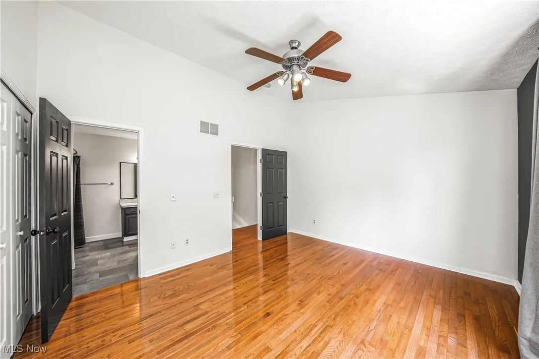 Primary Bedroom with Hardwood Flooring, Access to Bathroom and Dual Closets