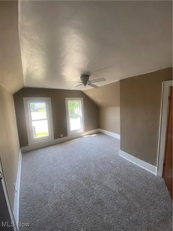 Bonus room featuring lofted ceiling, carpet, and ceiling fan