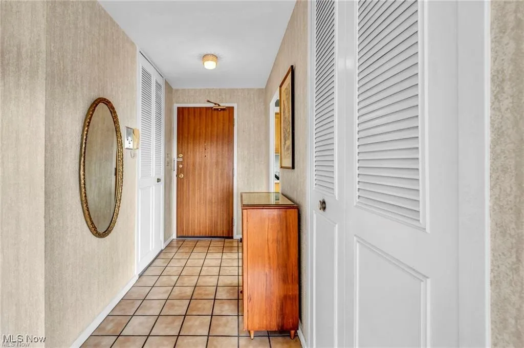 Hall with wallpapered walls and light tile patterned floors