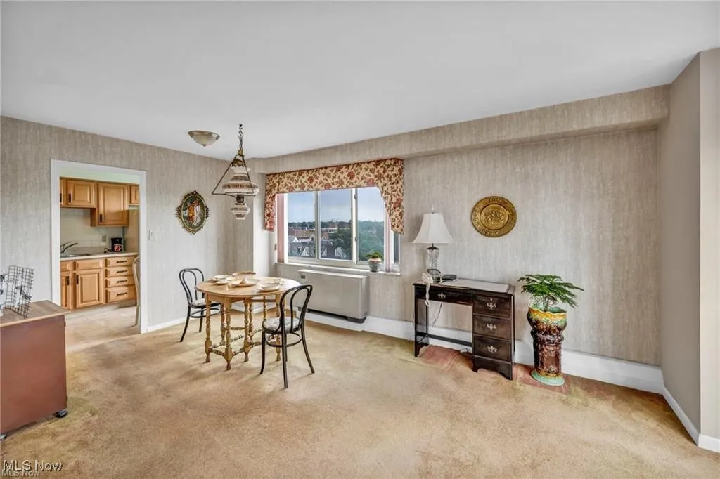 Dining room with wallpapered walls and light carpet