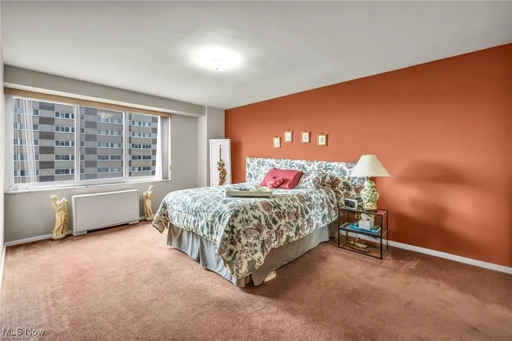 Bedroom with carpet floors and radiator heating unit