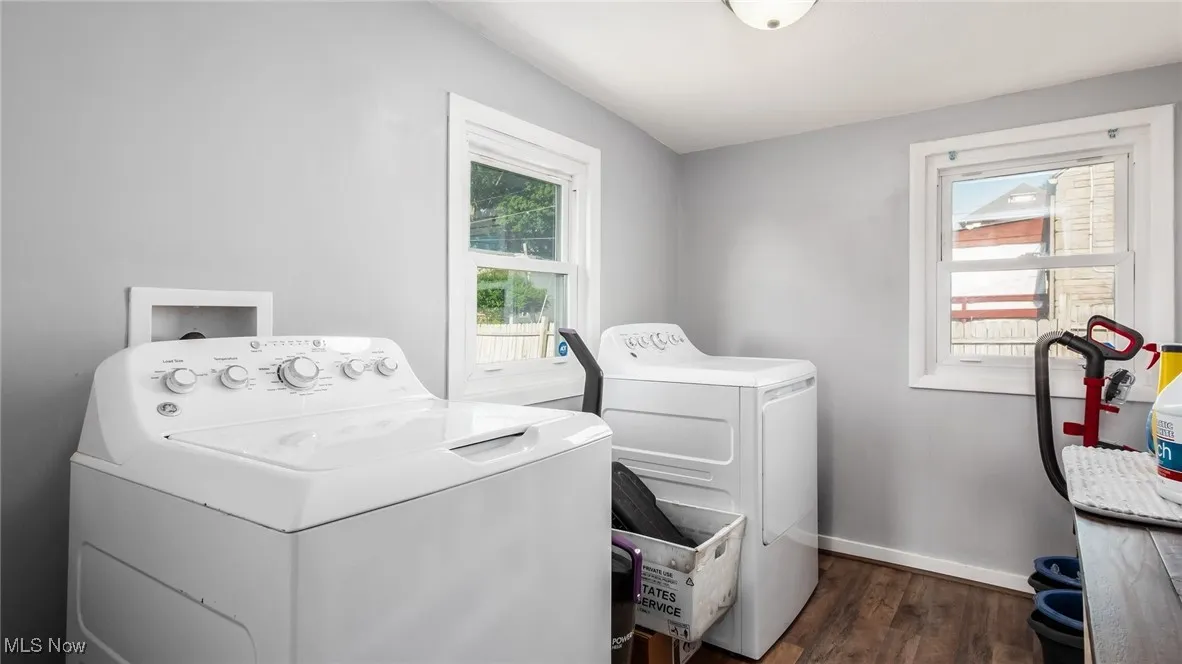 Laundry room featuring independent washer and dryer and dark wood finished floors