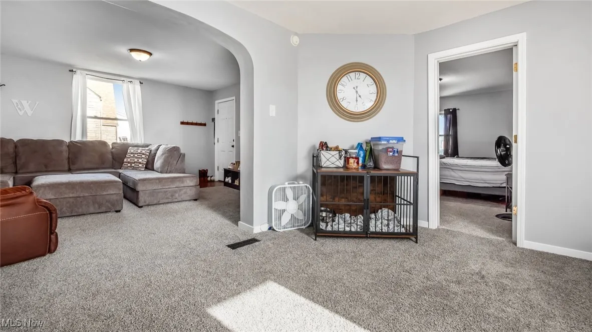 Living room with arched walkways and carpet flooring