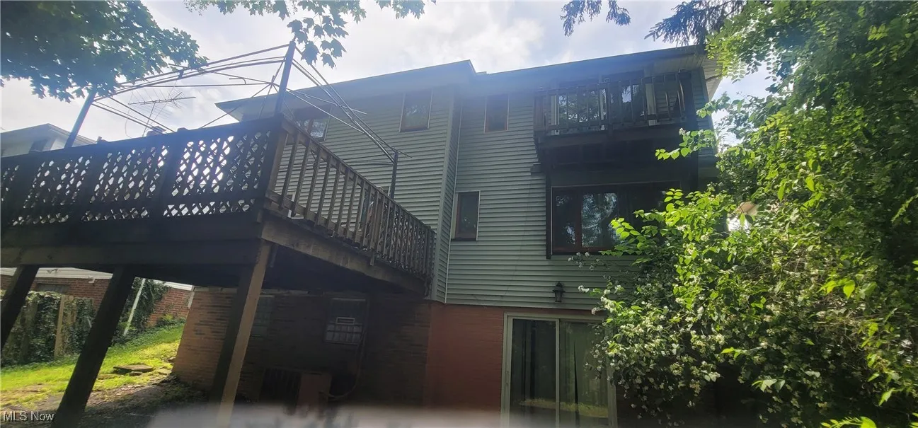 Rear view of house with brick siding and a deck