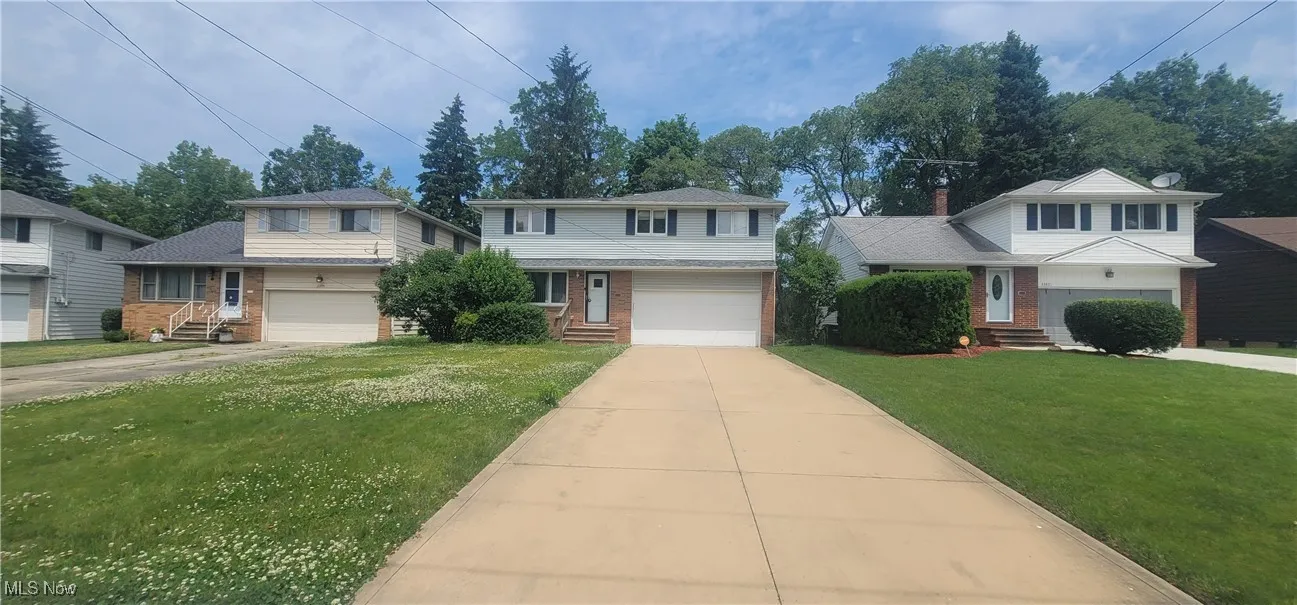 Traditional-style home featuring brick siding, concrete driveway, a front yard, and entry steps