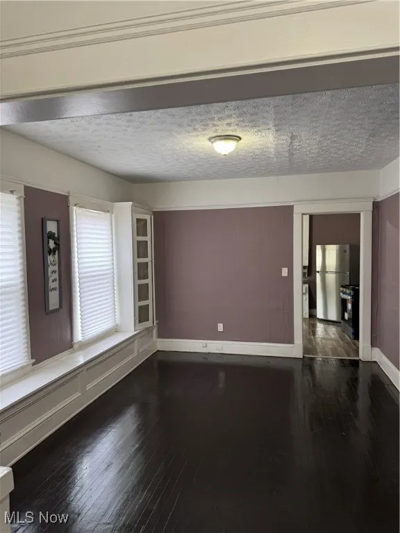 Spare room with hardwood / wood-style floors and a textured ceiling