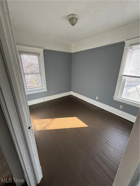 Unfurnished room with hardwood / wood-style flooring and healthy amount of natural light