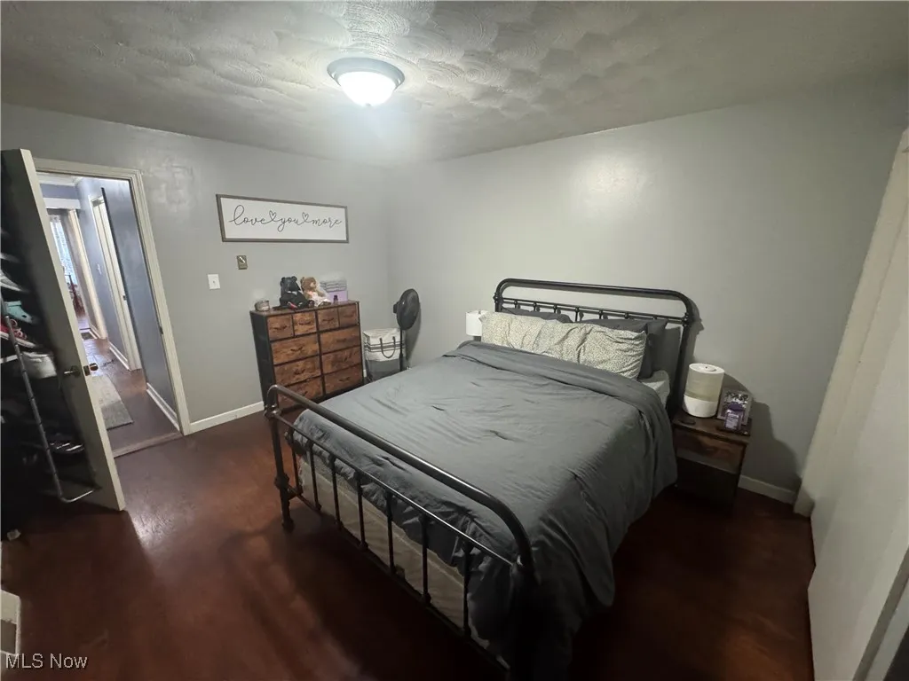 Bedroom featuring wood finished floors and a textured ceiling