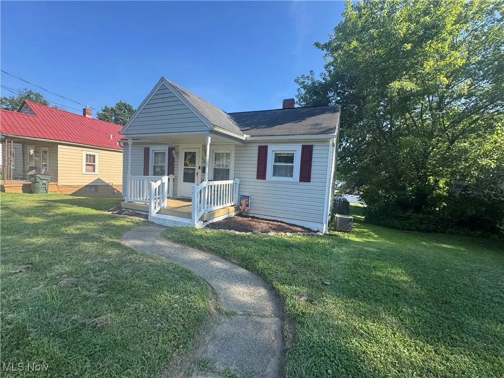 Bungalow with covered porch, a front lawn, and a chimney