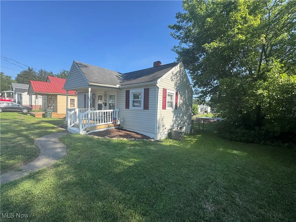 View of front facade featuring a porch and a chimney