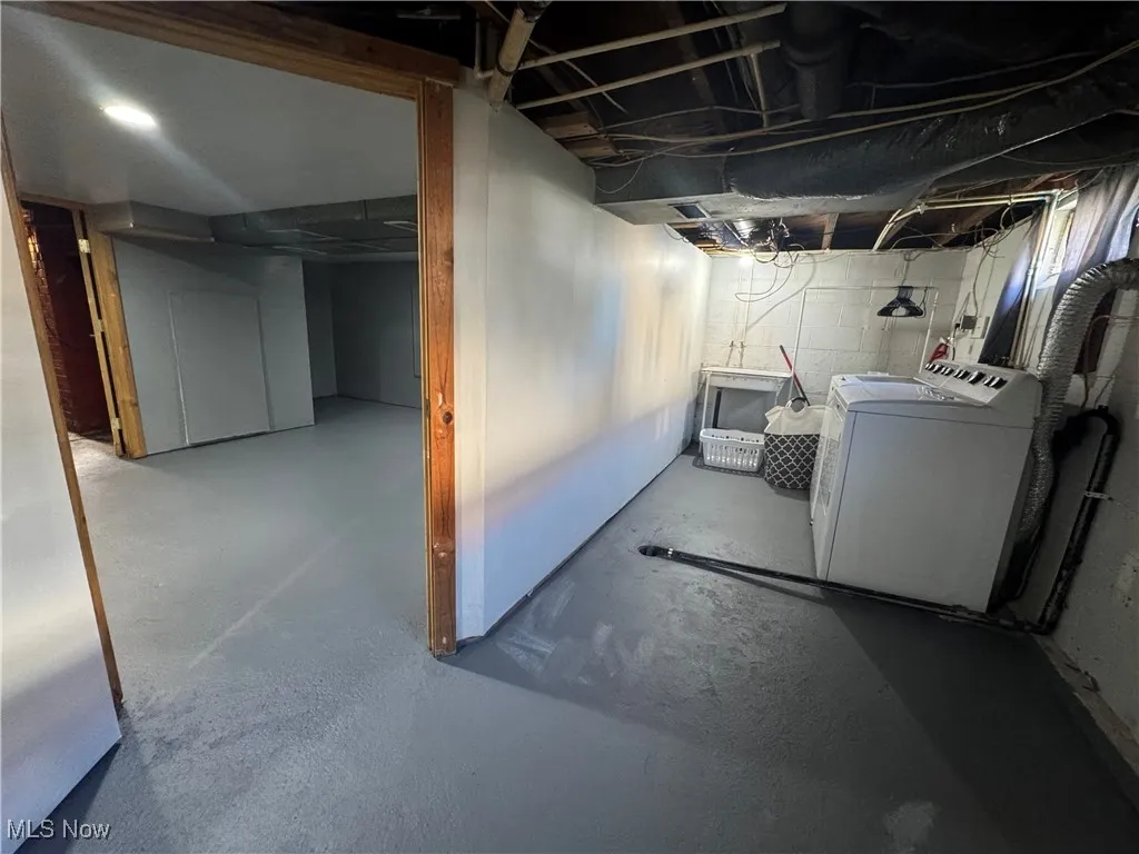 Unfinished below grade area featuring washer and dryer