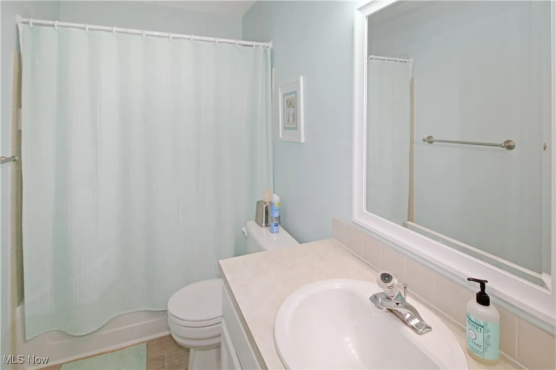 Bathroom with vanity and shower / bath combination with curtain