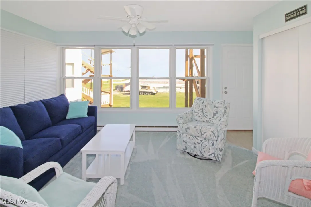 Living room with a ceiling fan and baseboard heating