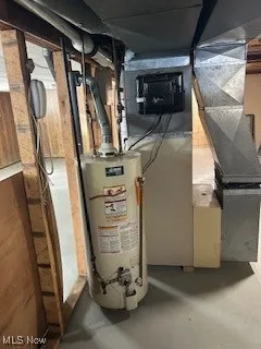 Utility room featuring water heater and heating unit