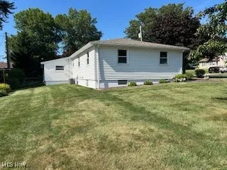 Rear view of property with a yard