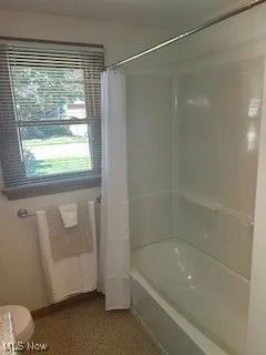 Full bath with shower / bath combination with curtain and toilet