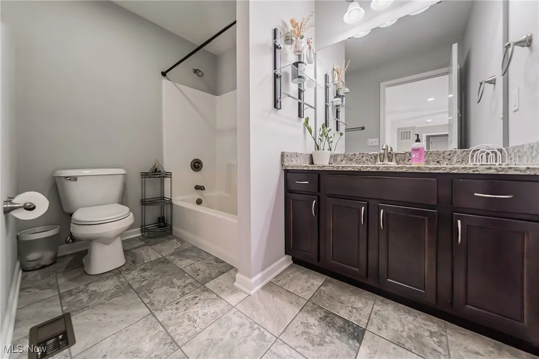 Full bath featuring vanity and washtub / shower combination