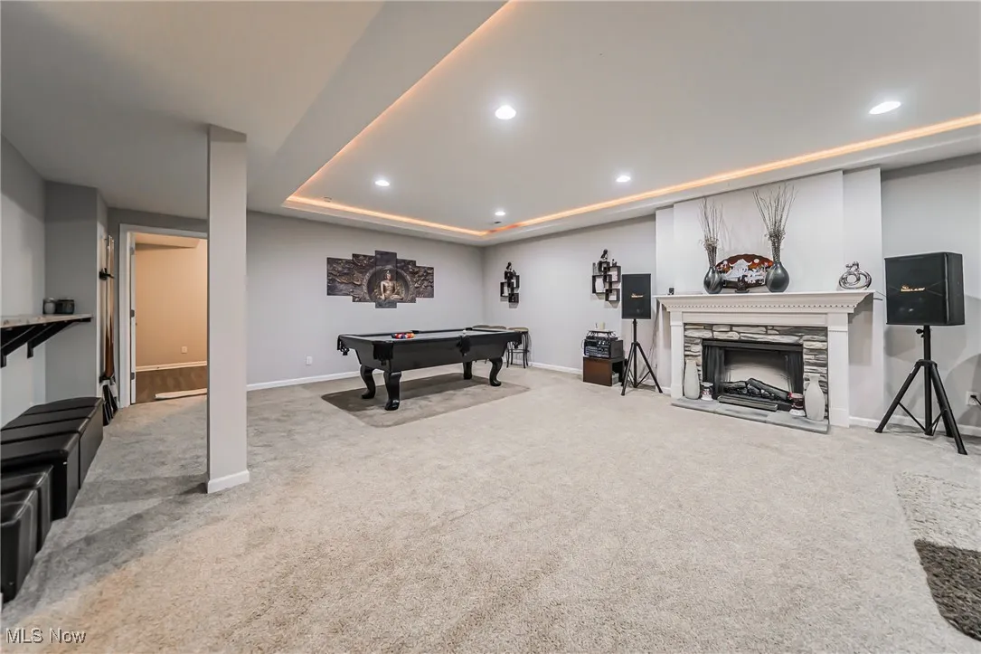Game room featuring carpet flooring, recessed lighting, a fireplace with raised hearth, and billiards