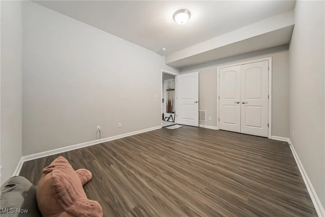 Unfurnished bedroom featuring dark wood finished floors and a closet