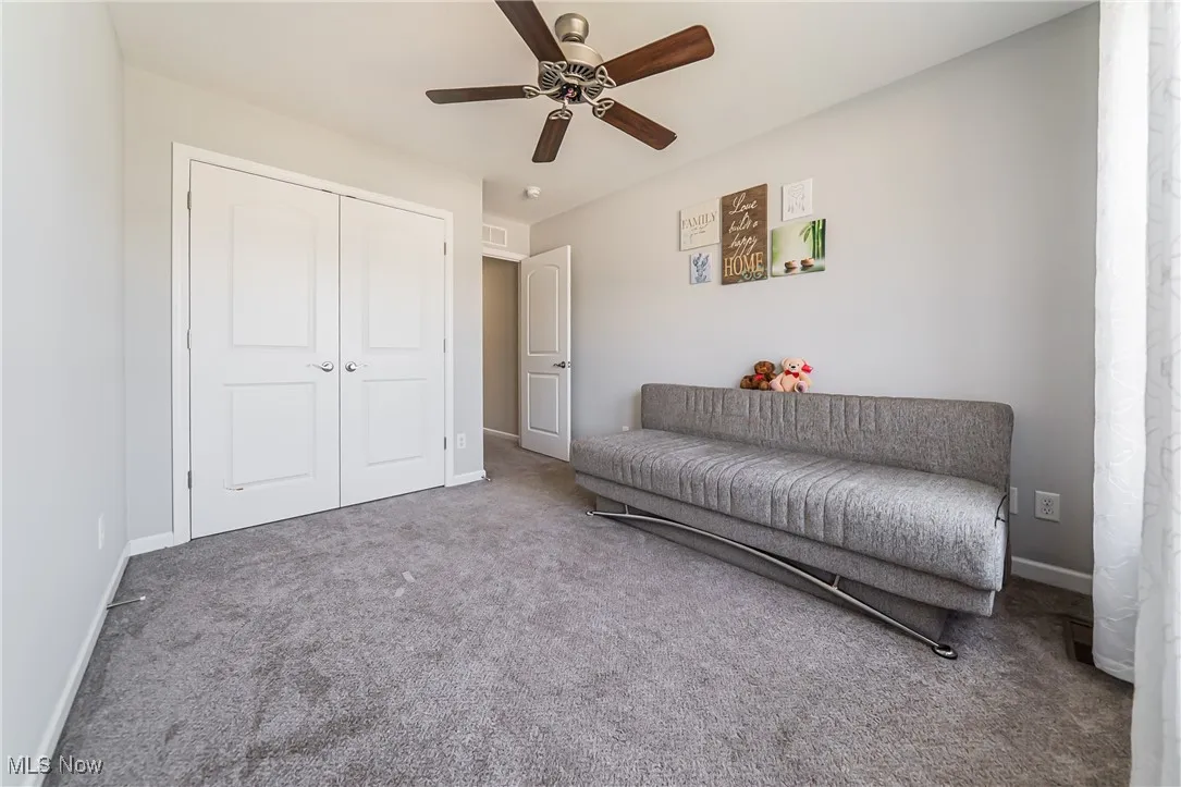 Living area with carpet and ceiling fan