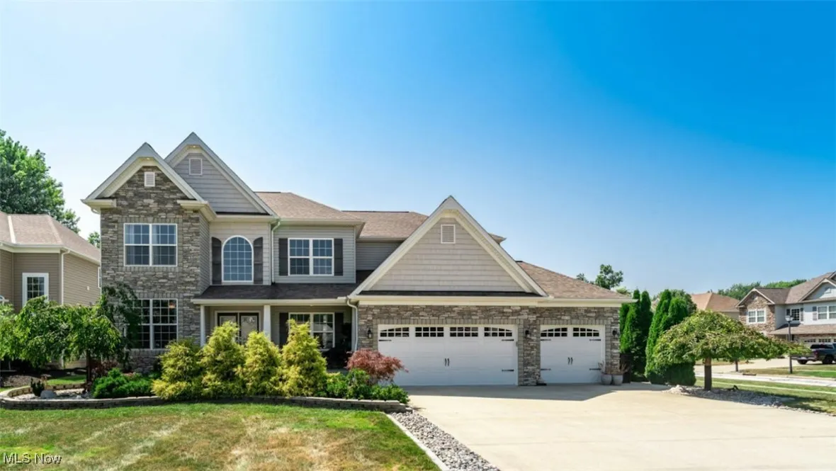 Craftsman-style home featuring stone siding, concrete driveway, and a garage
