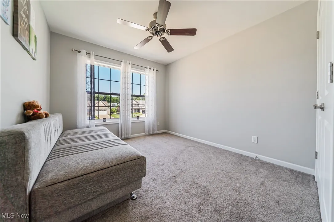 Living area with carpet floors and a ceiling fan