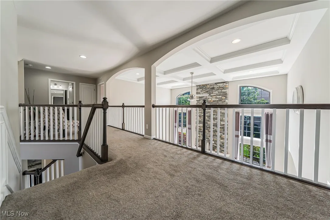 Hallway with carpet flooring, an upstairs landing, coffered ceiling, recessed lighting, and beam ceiling