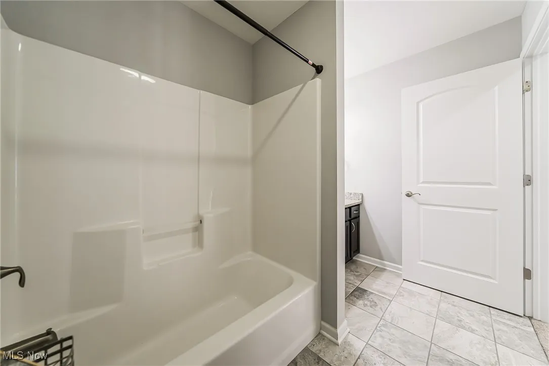 Full bath with marble finish floors, shower / bath combination, and vanity